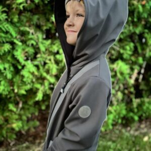 chłopiec w szare kurtce softshell stojący bokiem