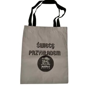 odblaskowa torba w kolorze srebrnym z czarnym nadrukiem świecę przykładem i logo Miapka Design